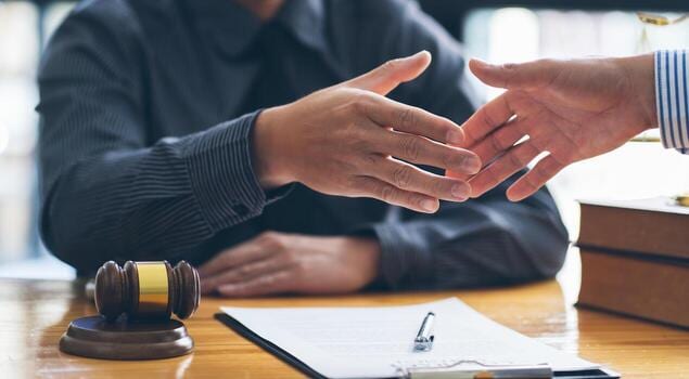 Balanza de la justicia junto a documentos legales sobre un escritorio de madera, simbolizando el equilibrio entre la inadmisión y la subsanación procesal.